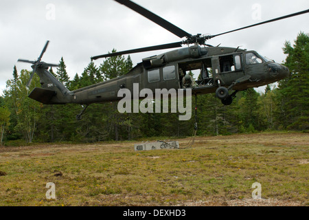 Sgt. Dave Gray, un capo equipaggio con il Maine esercito guardie nazionali 3° Battaglione, 142th reggimento di aviazione, orologi con attenzione per garantire che il 4000 pound blocco di cemento ha appena attaccato per il trasporto va fino in modo regolare e senza interruzioni per la UH-60 nero Foto Stock