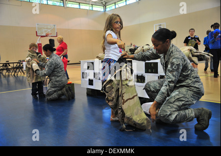 Stati Uniti Air Force aviatori assegnati al 4 disponibilità logistica Squadron aiutano i bambini don missione orientata postura di protezione ingranaggio durante il funzionamento Bug, la simulazione di una distribuzione per i bambini, presso Seymour Johnson Air Force Base, N.C., Sett. 19, 2013. Il childr Foto Stock