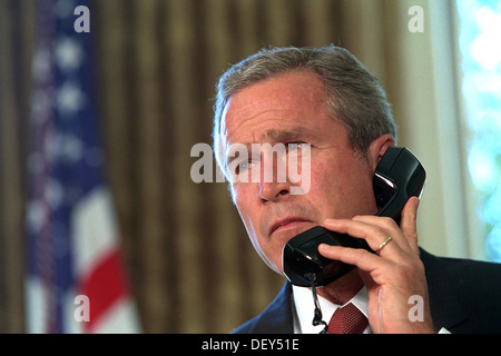 Il Presidente degli Stati Uniti George W. Bush parla al telefono con New York Gov. George Pataki e New York City Mayor Rudolph Giuliani costituzione in pegno il suo sostegno dopo gli attacchi terroristici al World Trade Center dall'Ufficio Ovale della Casa Bianca, 13 settembre 2001 a Washington, DC. Foto Stock