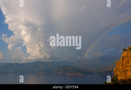 Il bizzarro tipiche rocce rosse delle Calanche di Piana e il mare mediterraneo nel golfo di Porto in background al di sotto di un Foto Stock