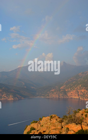 Il bizzarro tipiche rocce rosse delle Calanche di Piana e il mare mediterraneo nel golfo di Porto in background al di sotto di un Foto Stock