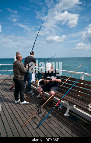 La gente della pesca in mare off Cromer Pier un passatempo popolare Norfolk East Anglia England Foto Stock