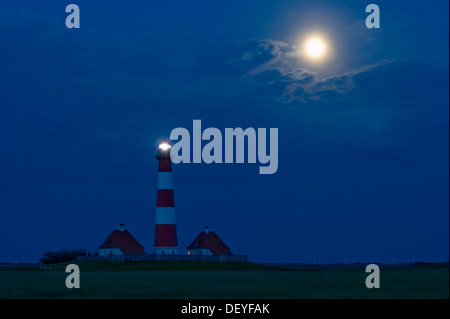 Faro e luna piena, scena notturna, Westerheversand, Westerhever, Eiderstedt, Frisia settentrionale, Schleswig-Holstein, Germania Foto Stock