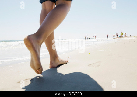 Holiday Maker correre a piedi nudi lungo la spiaggia di Westerland, Sylt, Nord Isole Frisone, Schleswig-Holstein, Germania Foto Stock