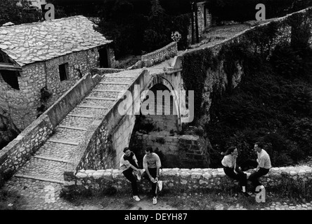 Persone che fanno ritorno a un qualche senso di normalità tra le rovine dopo l accordo di pace di Dayton. Mostar, Bosnia. 1996 Foto Stock