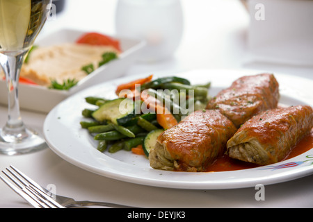 Bagno turco farcito involtini di cavolo servito insieme al vapore con fagiolini, carote e zucchine, complementate con hummus piastra e wh Foto Stock
