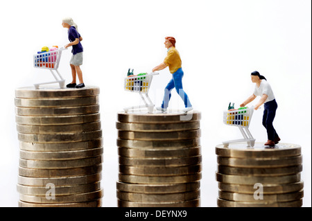 Statuine in miniatura con carrelli di shopping su una pila di monete, immagine simbolica per il rialzo dei prezzi dei prodotti alimentari Foto Stock