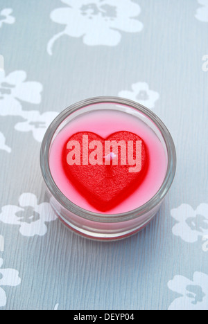 A forma di cuore candela in un vetro porta tealight, simbolo per amore Foto Stock