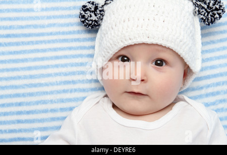 Sorridente baby giace sul retro sul letto Foto Stock