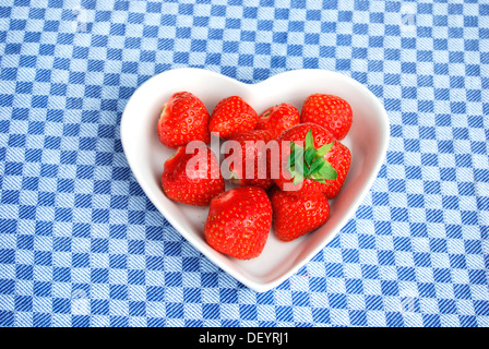 Fragole, a forma di cuore vaso di porcellana tovaglia a scacchi Foto Stock