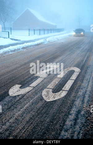 Pericolo di scivolamento in un traffico area calmata, neve granita su una strada wintery con nebbia, Borken, Gemen distretto, Muensterland Foto Stock