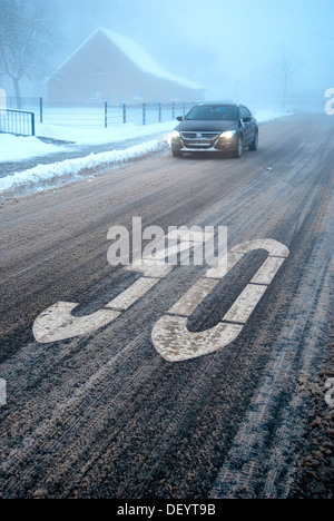 Pericolo di scivolamento in un traffico area calmata, neve granita su una strada wintery con nebbia, Borken, Gemen distretto, Muensterland Foto Stock