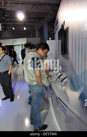 Pechino, Cina - 25 September, 2013, PT/ EXPO COMM China 2013, uno dei più grandi e influenti ICT ed Elettronica la scienza e la tecnologia di mostre in Asia. Persone prove 4G tecnologia. Credito: momo leif/Alamy Live News Foto Stock