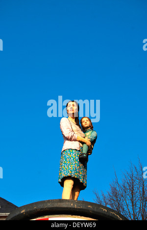 Lo straniero, la donna con il bambino in braccio, scultura su una colonna di pubblicità, Duesseldorf, nella Renania settentrionale-Vestfalia Foto Stock