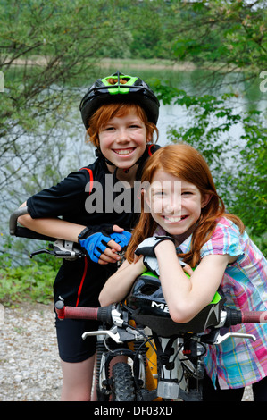 Due bambini, un ragazzo e una ragazza, con la mountain bike e caschi Foto Stock