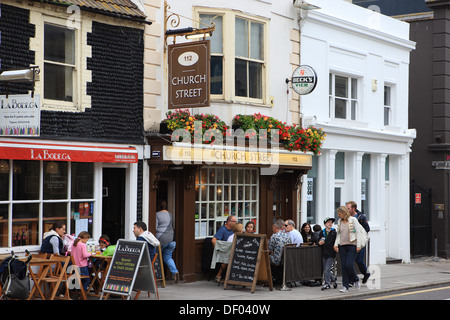 La gente seduta fuori a mangiare e a bere in caffetterie e ristoranti in Brighton Foto Stock