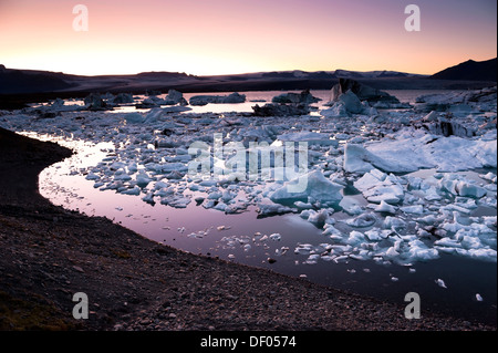 Blu e nero iceberg e cristalli di ghiaccio nella luce della sera, Joekulsárlón laguna glaciale, ghiacciaio Vatnajoekull, Austurland Foto Stock