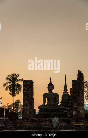 Silhouette di un Buddha seduto statua al crepuscolo, Wat Mahathat tempio, Sukhothai Historical Park, Patrimonio Mondiale dell UNESCO Foto Stock