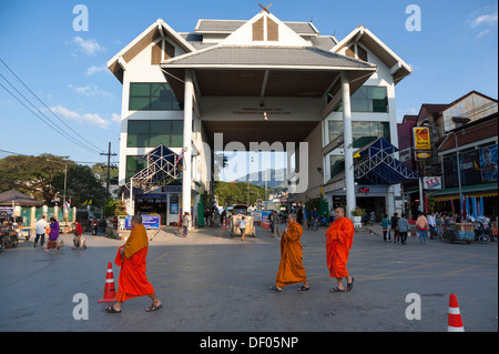 I monaci a piedi nella parte anteriore del posto di confine tra Myanmar Birmania, e Mae Sai, Thailandia del Nord, città nel nord della Thailandia Foto Stock