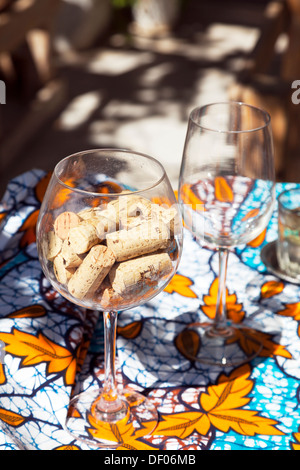 I tappi di sughero da una bottiglia di vino all'interno di in un bicchiere accanto al vetro vuoto Nydri Nidri Lefkada Lefkada isola greca Grecia Foto Stock