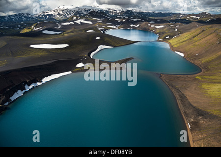 Vista aerea, Lago Skyggnisvatn, moss-coperto il paesaggio e le montagne ricoperte di neve, islandese Highlands, Islanda, Europa Foto Stock