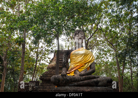 Seduto statua del Buddha di fronte un chedi, complesso tempio di Wat Khao Phnom Phloeng, Si Satchanalai Parco storico Foto Stock