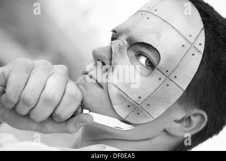 Monocromatico giovane serio in spook maschera con il coltello Foto Stock