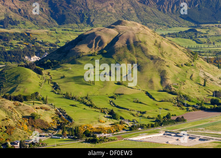 Verdi colline e prati illuminata dalla calda luce del mattino vicino a Queenstown visto da Kelvin Heights, Isola del Sud, Nuova Zelanda Foto Stock