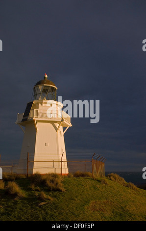 Waipapa Point Lighthouse nella luce della sera con nuvole scure sul retro, Otara, Fortrose, Southland, Nuova Zelanda Foto Stock