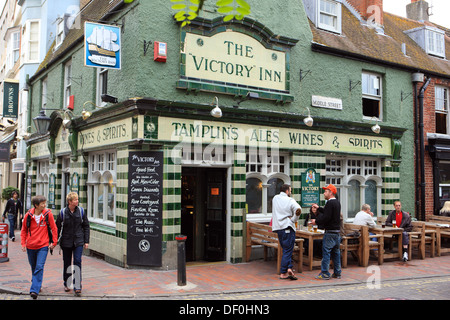 Persone in chat e bere a tavoli e sedie fuori la vittoria Inn in Brighton, East Sussex, Inghilterra Foto Stock