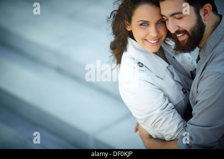 Immagine di donna felice guardando la fotocamera mentre è abbracciato dal suo innamorato Foto Stock