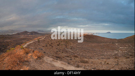 Percorso attraverso il cerchio del Montana Amarilla, un vecchio cono vulcanico vicino alla costa del Silenciio, Tenerife, guardando verso El Medano Foto Stock