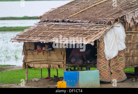 Persone sedersi nella loro casa in un campo esterno Kinpun, Birmania. Foto Stock