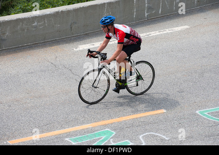 Ciclista in sella determinata barriera stradale la pedalata Foto Stock