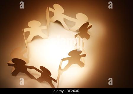 Gruppo di persone che si tengono per mano in un cerchio Foto Stock
