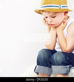 Triste ragazzo carino con il suo cappello di paglia Foto Stock