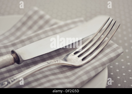 Piastra bianca, coltello e forchetta sulla luce polka dot sfondo.