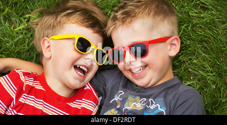 Sorridente giovani fratelli indossando occhiali da sole di fantasia Foto Stock