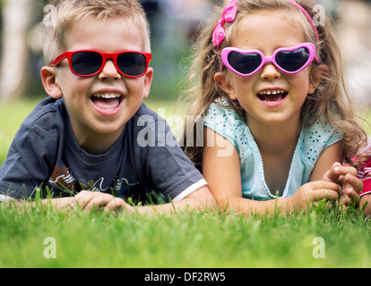 Carino piccoli bambini con occhiali da sole di fantasia Foto Stock