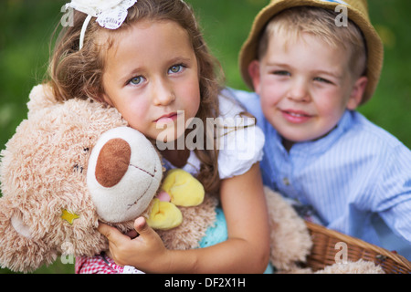 Felici i bambini azienda simpatico orsacchiotto giocattolo Foto Stock