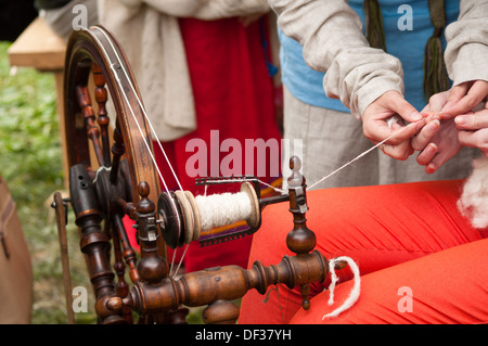 Ruota di filatura con mani rendendo filati di lana Foto Stock