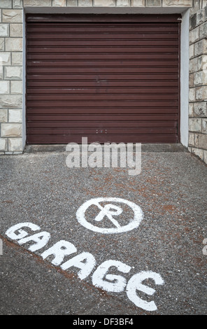 Attenzione text mark su asfalto di fronte chiuso la porta del garage Foto Stock