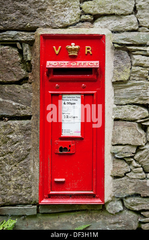 Primo piano della cassetta postale rossa vecchia cassetta letteraria vittoriana incastonata in pietra Cumbria Inghilterra Regno Unito Gran Bretagna Foto Stock