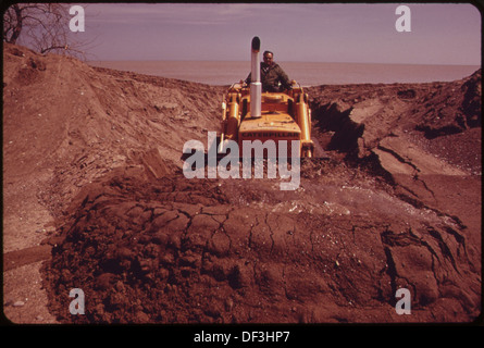 BULLDOZER SGORBIE UN CANALE intrappolato tra le acque di esondazione e il lago Michigan in Sion 551947 Foto Stock