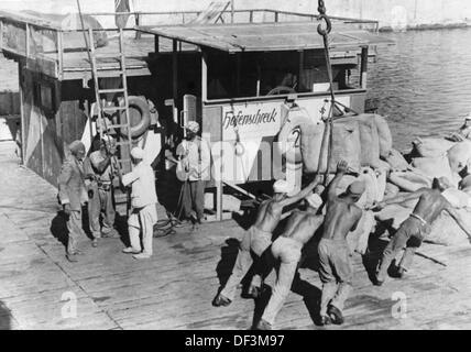 L'immagine della Propaganda nazista! Raffigura locali e soldati della Wehrmacht tedesca che scaricano una nave da trasporto in un porto libico, pubblicato il 31 ottobre 1941. Luogo sconosciuto. Fotoarchiv für Zeitgeschichte Foto Stock