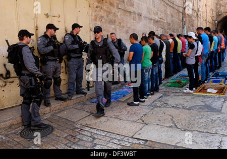 Armati di confine israeliano poliziotti di guardia accanto a quei palestinesi che sono state vietate per immettere Akza moschea e sono in preghiera nel quartiere musulmano della città vecchia di Gerusalemme Foto Stock