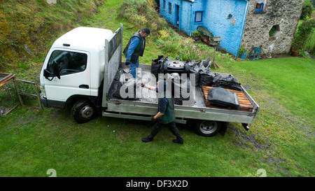 Carbone uomo che consegna sacchi di antracite gallese solido erogazione di combustibile Per il riscaldamento domestico in stufa a carbone rurale Carmarthenshire Galles REGNO UNITO KATHY DEWITT Foto Stock