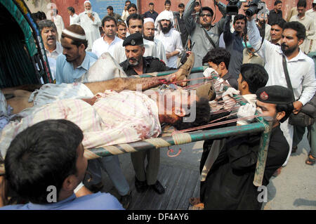 Bomba Blast vittime della strada Charsadda vengono spostate alla Signora Lettura in ospedale per il trattamento, nella città di Peshawar Venerdì, 27 settembre 2013. Circa 19 persone sono state uccise e 44 altri subito lesioni in un'esplosione all'interno di un bus sulla strada Charsadda. L'attacco mirato un bus del segretariato civile dipendenti che stava trasportando circa 60 persone. La bomba è stata collocata nella parte posteriore del bus. Secondo l'eliminazione della bomba squad (BDS), la bomba conteneva circa sei o sette chilogrammi di materiale esplosivo e aveva un dispositivo temporizzato ad esso collegato. L'esplosione è stata così ho... Foto Stock