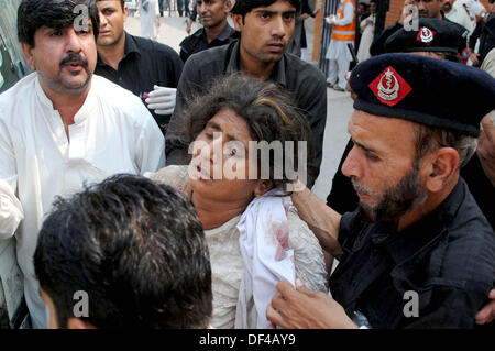 Bomba Blast vittime della strada Charsadda vengono spostate alla Signora Lettura in ospedale per il trattamento, nella città di Peshawar Venerdì, 27 settembre 2013. Circa 19 persone sono state uccise e 44 altri subito lesioni in un'esplosione all'interno di un bus sulla strada Charsadda. L'attacco mirato un bus del segretariato civile dipendenti che stava trasportando circa 60 persone. La bomba è stata collocata nella parte posteriore del bus. Secondo l'eliminazione della bomba squad (BDS), la bomba conteneva circa sei o sette chilogrammi di materiale esplosivo e aveva un dispositivo temporizzato ad esso collegato. L'esplosione è stata così ho... Foto Stock