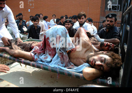 Bomba Blast vittime della strada Charsadda vengono spostate alla Signora Lettura in ospedale per il trattamento, nella città di Peshawar Venerdì, 27 settembre 2013. Circa 19 persone sono state uccise e 44 altri subito lesioni in un'esplosione all'interno di un bus sulla strada Charsadda. L'attacco mirato un bus del segretariato civile dipendenti che stava trasportando circa 60 persone. La bomba è stata collocata nella parte posteriore del bus. Secondo l'eliminazione della bomba squad (BDS), la bomba conteneva circa sei o sette chilogrammi di materiale esplosivo e aveva un dispositivo temporizzato ad esso collegato. L'esplosione è stata così ho... Foto Stock